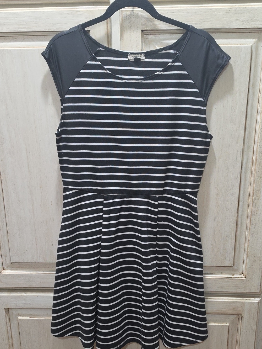 Black and white striped mini dress featuring faux-leather cap sleeve accents.